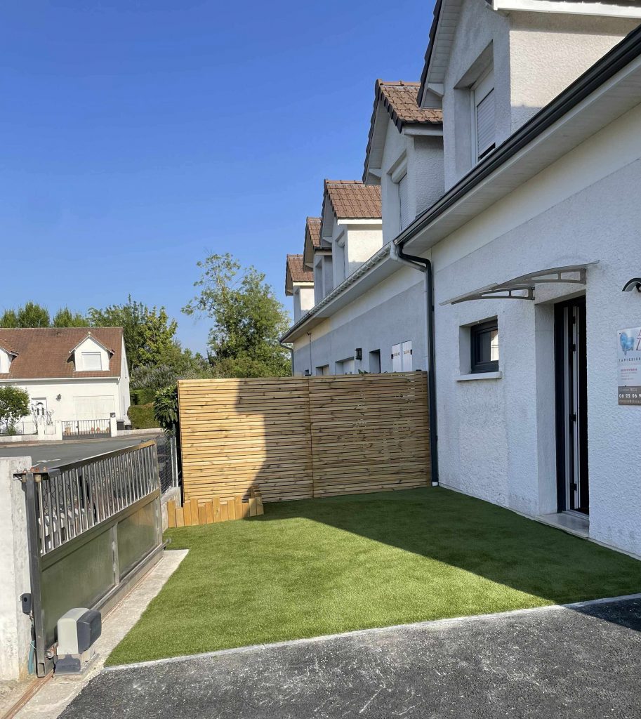 Entrée de maison aménagée à Bruges avec enrobé et gazon synthétique