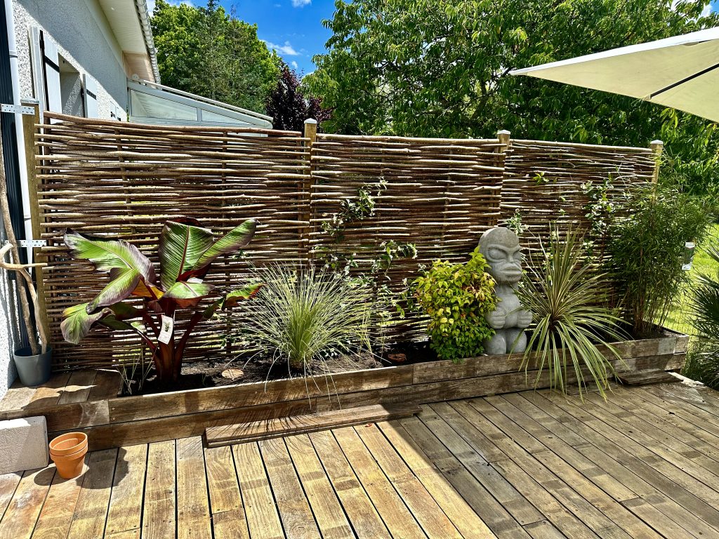 Aménagement paysager avec clôture en bois naturel et jardinière à Bruges près de Bordeaux
